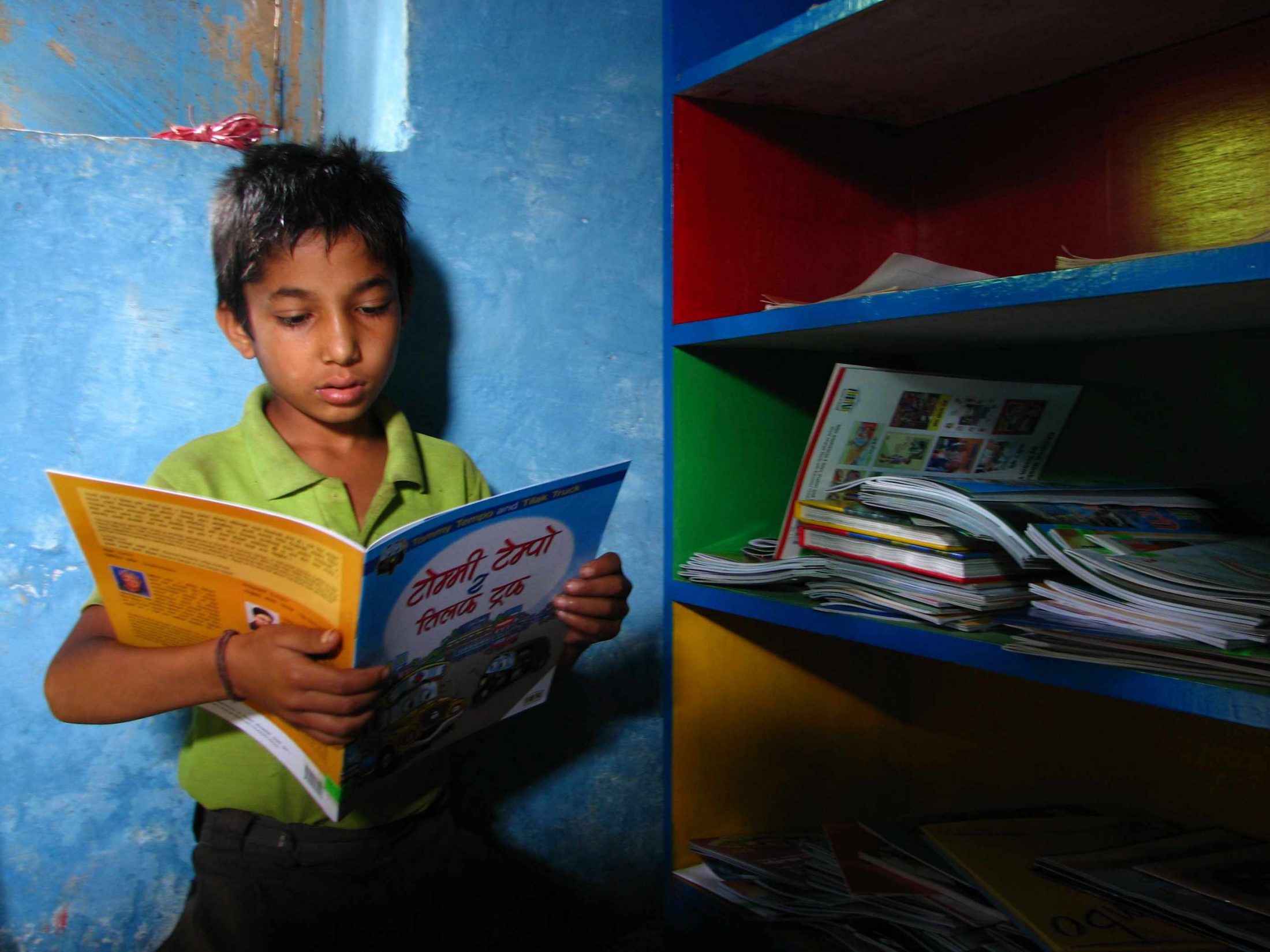 ROOM TO READ Nepali schoolboy reads to himself in a quiet corner scaled - thedotgood.